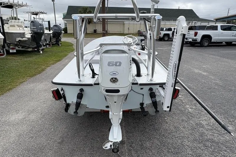 Slide: The Image of 2025 East Cape EVO boat with 60 HP engine, parked in a lot. - 2