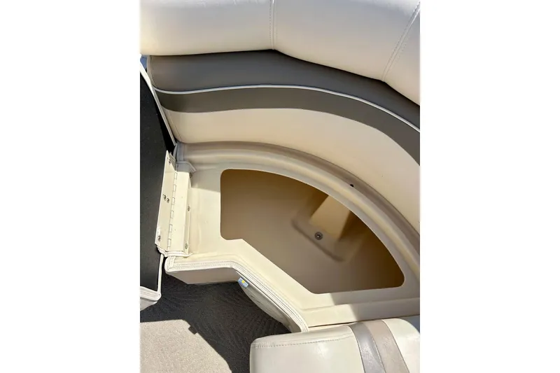 Slide: The Image of 2006 Bennington 2250 RL boat seat storage compartment, open and empty, with beige upholstery. - 19