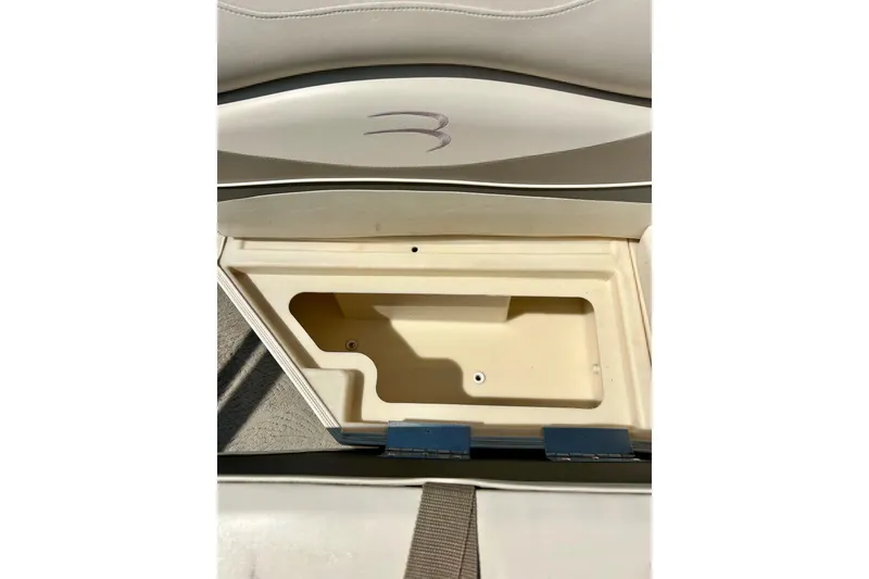 Slide: The Image of 2006 Bennington 2250 RL boat storage compartment with beige interior and cushioned seating. - 27