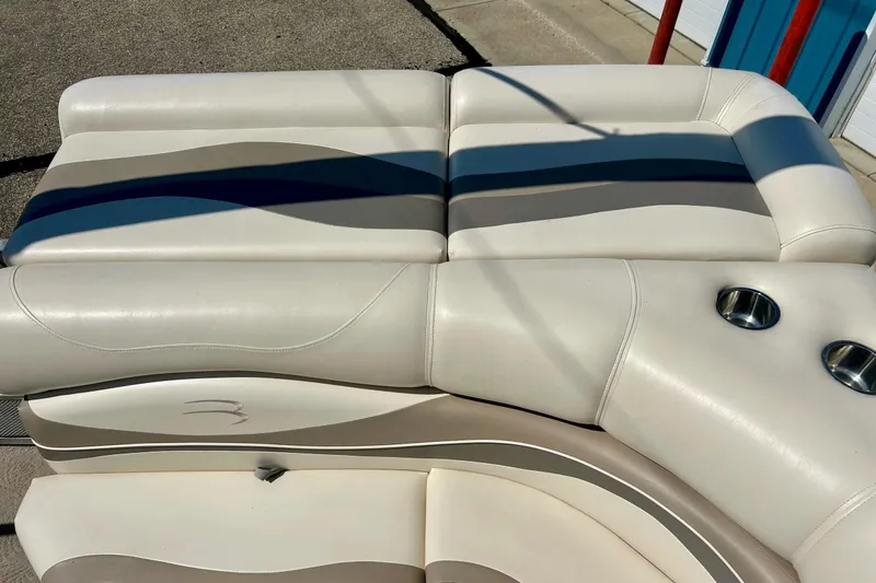 Slide: The Image of 2006 Bennington 2250 RL boat seating with cup holders, featuring white and beige upholstery. - 37