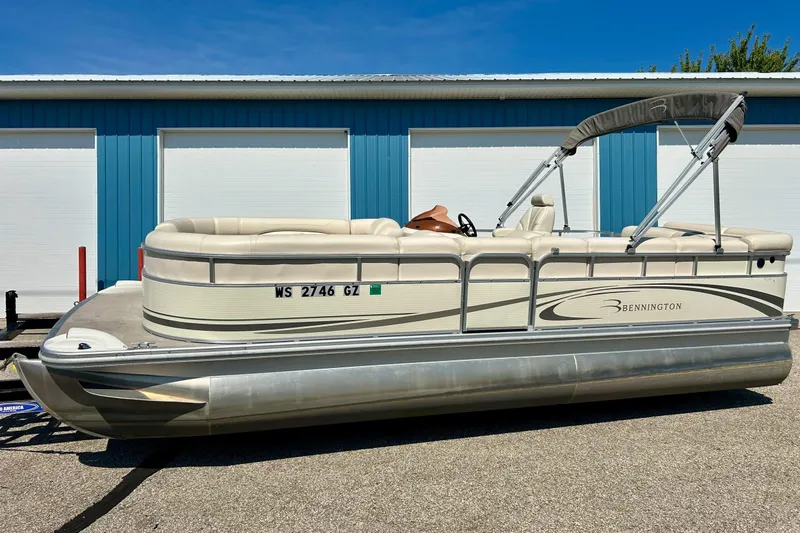 Slide: The Image of 2006 Bennington 2250 RL pontoon boat parked near blue storage units. - 43