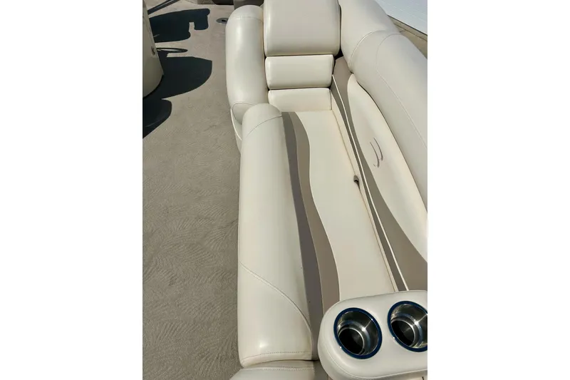 Slide: The Image of 2006 Bennington 2250 RL boat interior with beige seating and cup holders. - 7