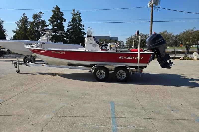 Slide: The Image of 2014 Blazer Bay 2170 boat on trailer with Yamaha outboard motor, parked outdoors. - 6