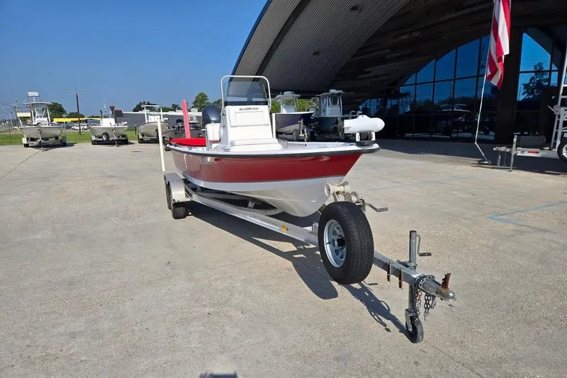 Slide: The Image of 2014 Blazer Bay 2170 boat on trailer, parked outdoors under clear blue sky. - 8