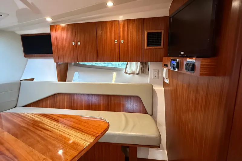 Slide: The Image of 2014 Pursuit SC 365i Sport Coupe interior with wood cabinetry and seating area. - 18