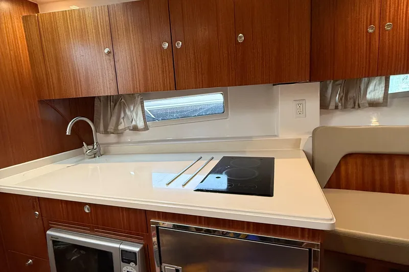 Slide: The Image of 2014 Pursuit SC 365i Sport Coupe kitchen with stove, sink, and wooden cabinets. - 19
