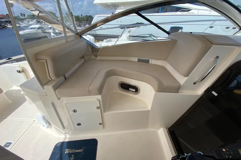 Slide: The Image of 2014 Pursuit SC 365i Sport Coupe interior with beige seating and welcome mat. - 3