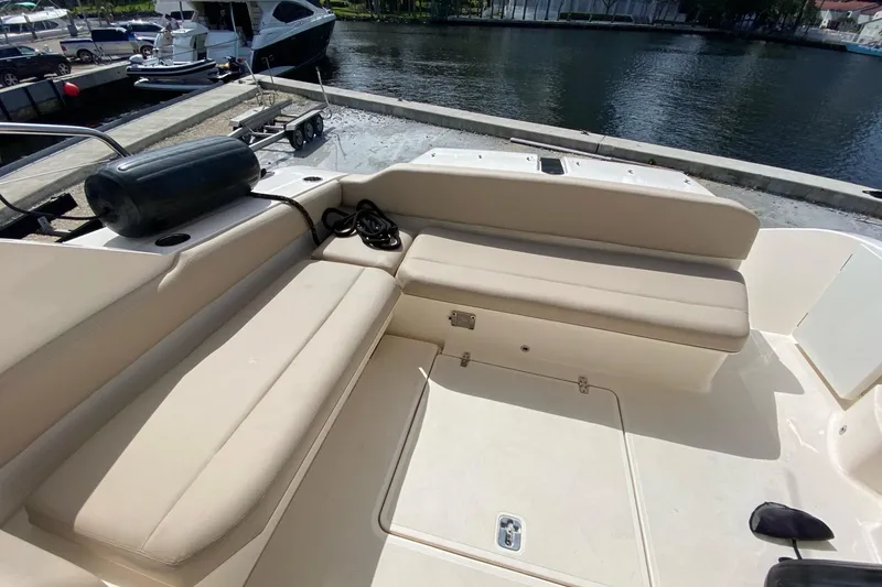 Slide: The Image of 2014 Pursuit SC 365i Sport Coupe boat interior with beige seating at dockside. - 4