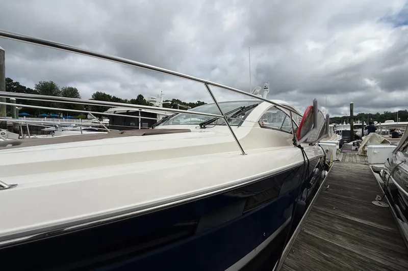 Slide: The Image of 2014 Pursuit SC 365i Sport Coupe docked at a marina under cloudy skies. - 6