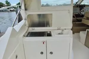 Slide: The Image of 2014 Pursuit SC 365i Sport Coupe boat interior with kitchenette and seating area. - 8