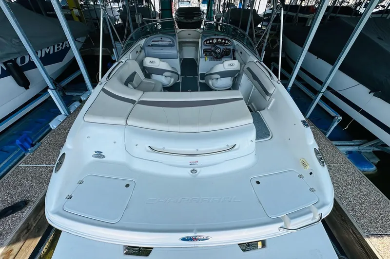 Slide: The Image of 2005 Chaparral 220 SSi boat interior, featuring seating and dashboard, docked in a marina. - 15