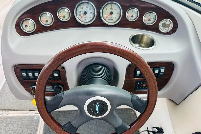 Slide: The Image of 2005 Chaparral 220 SSi boat dashboard with wood-trimmed steering wheel and gauges. - 19