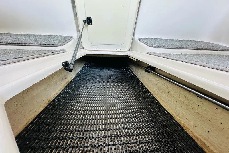 Slide: The Image of 2005 Chaparral 220 SSi boat storage compartment with open hatch and carpeted interior. - 24
