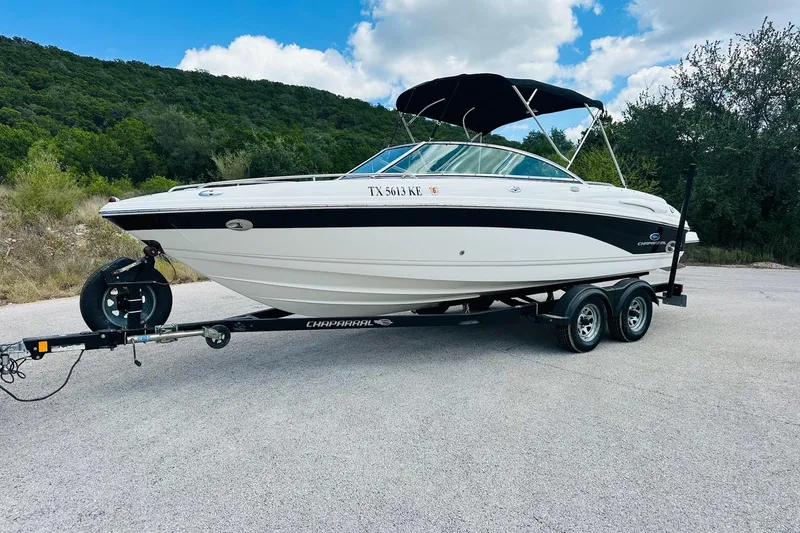 Slide: The Image of 2005 Chaparral 220 SSi boat on trailer, parked outdoors with scenic background. - 9