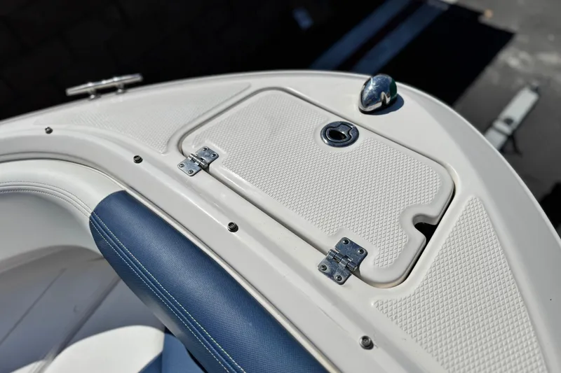 Slide: The Image of 2014 Chaparral 21 H2O Sport boat bow with storage compartment and blue seating. - 12
