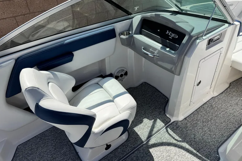 Slide: The Image of 2014 Chaparral 21 H2O Sport boat interior with white and blue seating and dashboard. - 21