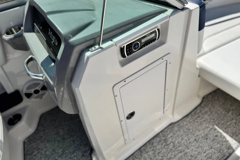 Slide: The Image of 2014 Chaparral 21 H2O Sport boat interior with control panel and storage compartment. - 22