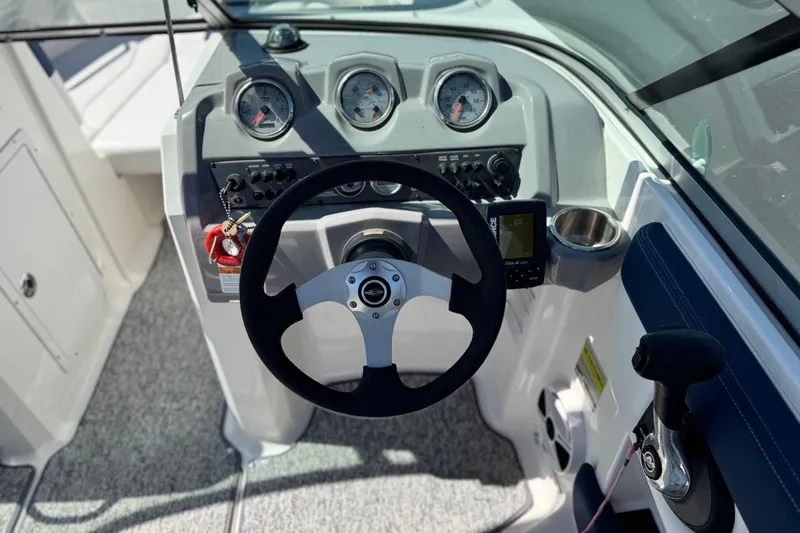 Slide: The Image of 2014 Chaparral 21 H2O Sport boat dashboard with steering wheel and gauges. - 25