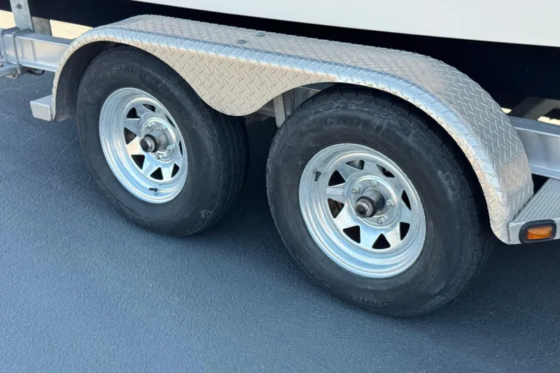 Slide: The Image of Trailer wheels of a 2014 Chaparral 21 H2O Sport boat, featuring diamond plate fenders. - 28