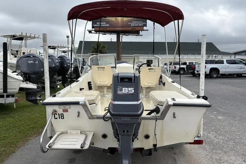 Slide: The Image of 1996 Key West 1720 Dual Console boat with outboard motor and red canopy. - 11