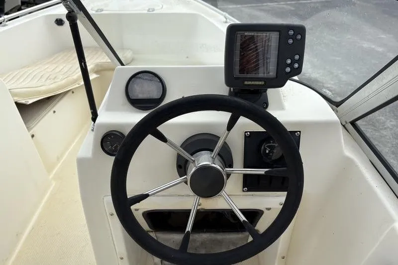 Slide: The Image of 1996 Key West 1720 Dual Console boat steering wheel and dashboard with navigation equipment. - 14