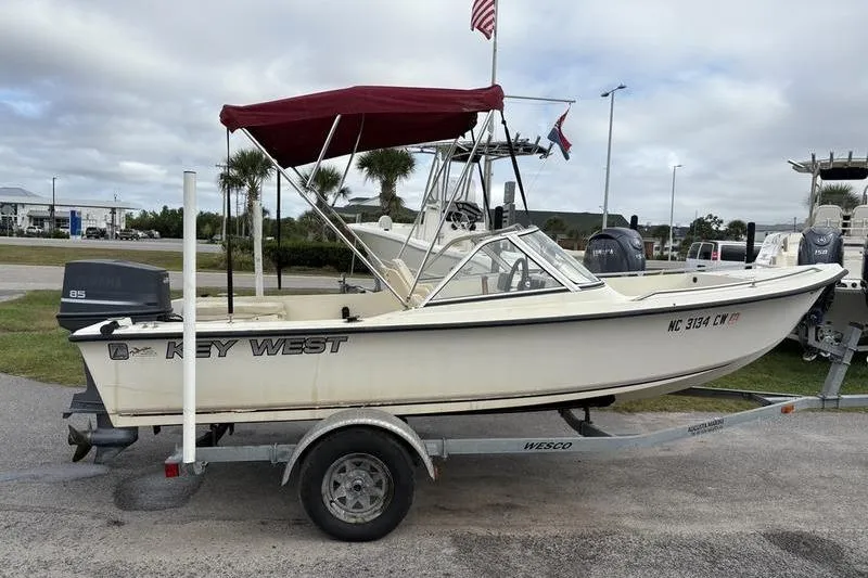 Slide: The Image of 1996 Key West 1720 Dual Console boat on trailer with red canopy and outboard motor. - 6