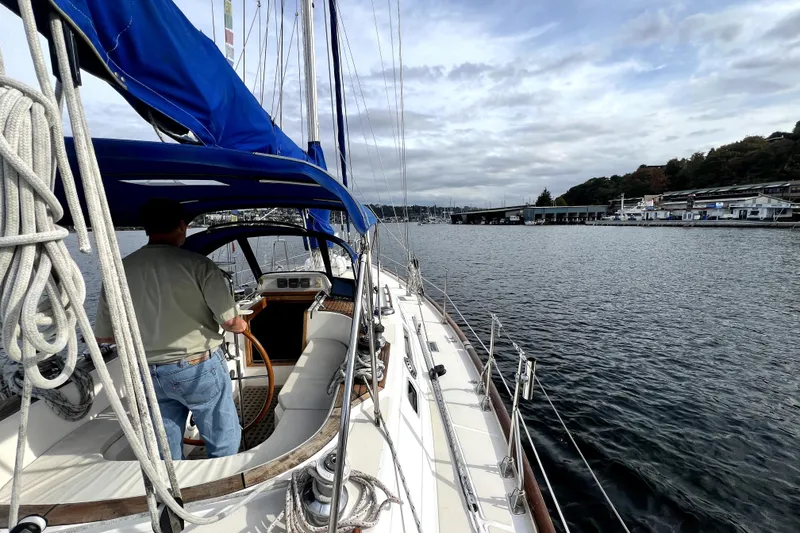 Slide: The Image of Sailboat Taswell 43 from 1989 on calm waters, with a person steering. - 15