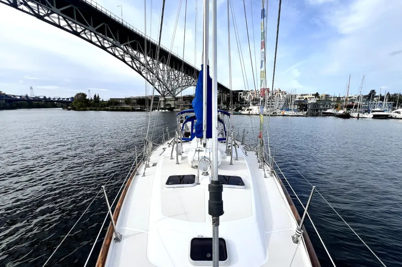 Slide: The Image of 1989 Taswell 43 sailboat under bridge, calm waters, marina in background. - 21