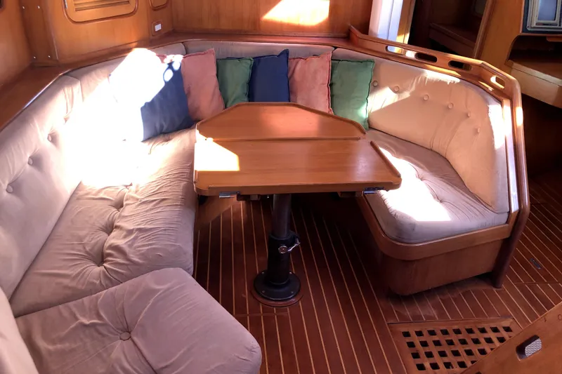 Slide: The Image of Cozy interior of 1989 Taswell 43 sailboat with cushioned seating and wooden table. - 26