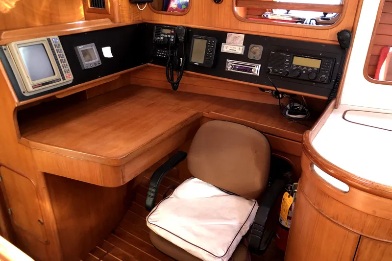 Slide: The Image of Navigation station of 1989 Taswell 43 yacht with wooden desk and communication equipment. - 27