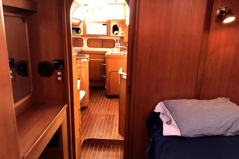 Slide: The Image of Interior of 1989 Taswell 43 yacht, featuring wooden cabinetry and cozy sleeping area. - 30
