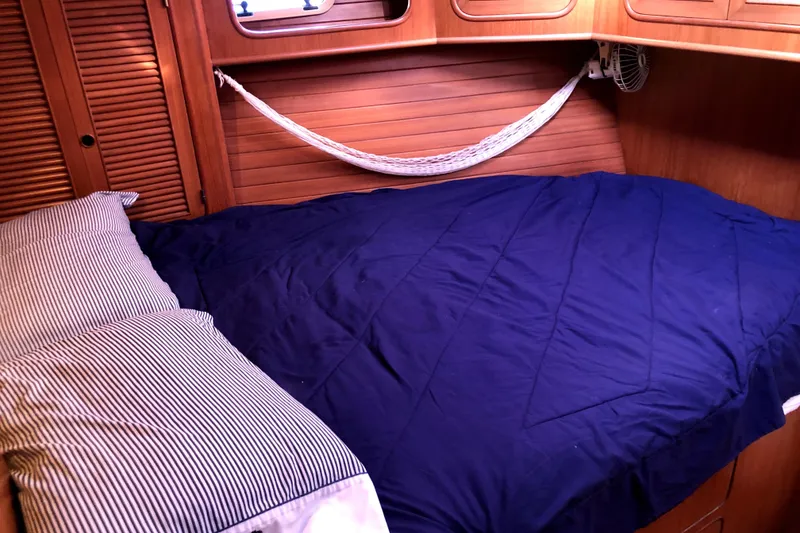 Slide: The Image of Cozy cabin interior of 1989 Taswell 43 sailboat with blue bedding and wooden paneling. - 31