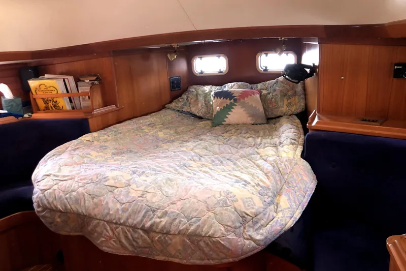 Slide: The Image of Cozy cabin interior of 1989 Taswell 43 sailboat with bed and wooden shelves. - 36