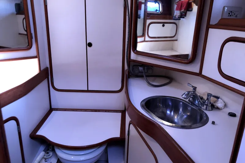 Slide: The Image of 1989 Taswell 43 yacht bathroom with sink, mirror, and storage cabinets. - 38