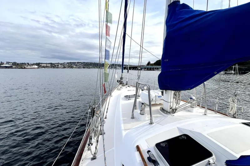 Slide: The Image of Sailing on a 1989 Taswell 43 yacht with colorful flags and scenic waterfront views. - 6