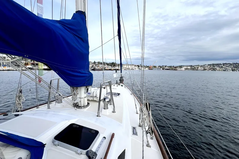 Slide: The Image of 1989 Taswell 43 sailboat on calm waters with cityscape in the background. - 7