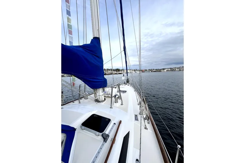 Slide: The Image of Sailing on a 1989 Taswell 43 yacht with blue sail cover, calm waters. - 8