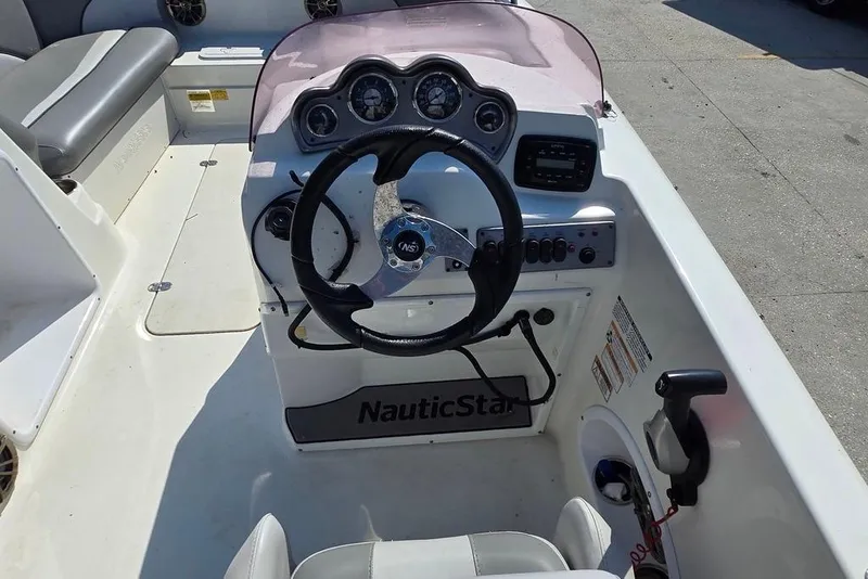 Slide: The Image of 2021 NauticStar 203 SE boat dashboard with steering wheel and control panel. - 11