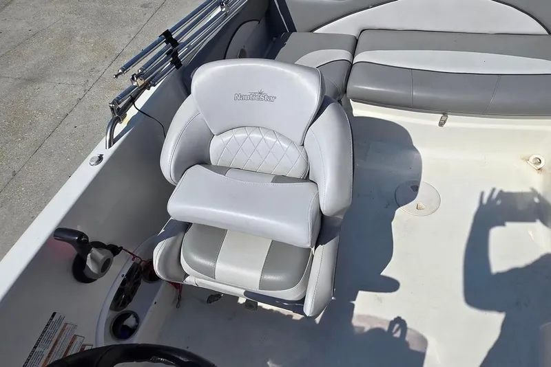 Slide: The Image of 2021 NauticStar 203 SE boat interior with gray seating and fishing rod holders. - 12