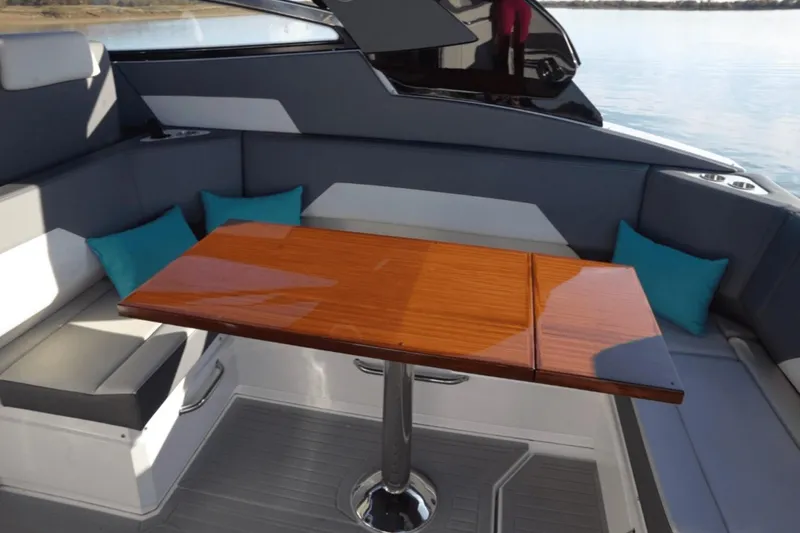 Slide: The Image of Luxurious seating area on 2022 Cruisers 42 GLS yacht with wooden table and teal cushions. - 16
