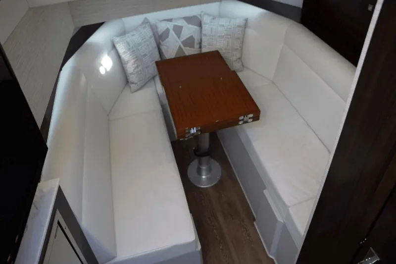 Slide: The Image of Luxurious 2022 Cruisers 42 GLS yacht interior with white seating and wooden table. - 28