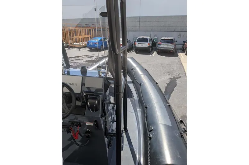 Slide: The Image of 2022 Zodiac 20 boat parked, showing interior and control panel in a parking lot. - 10