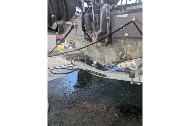 Slide: The Image of Damaged Zodiac 20 boat hull on trailer, showing wear and corrosion, 2022 model. - 12