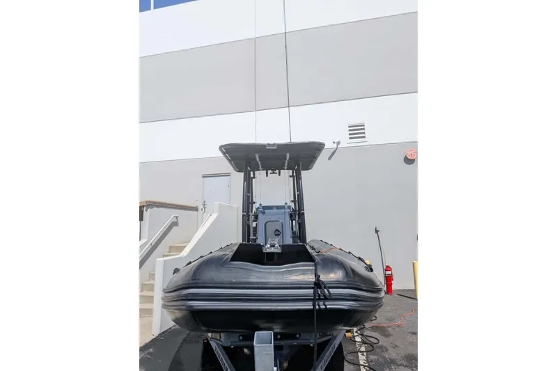 Slide: The Image of 2022 Zodiac 20 inflatable boat on trailer, parked near a building. - 18