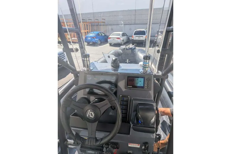 Slide: The Image of Interior view of a 2022 Zodiac 20 boat dashboard with steering wheel and controls. - 20