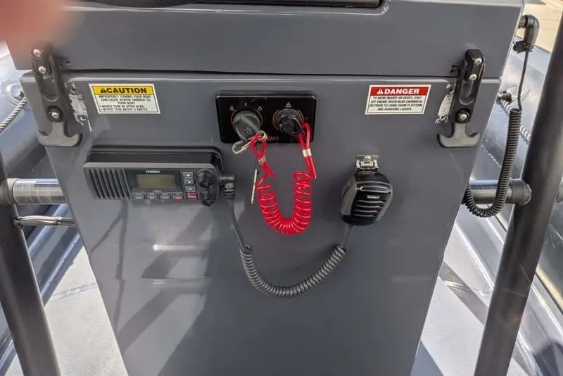 Slide: The Image of Control panel of a 2022 Zodiac 20 boat with radio and safety warnings. - 21