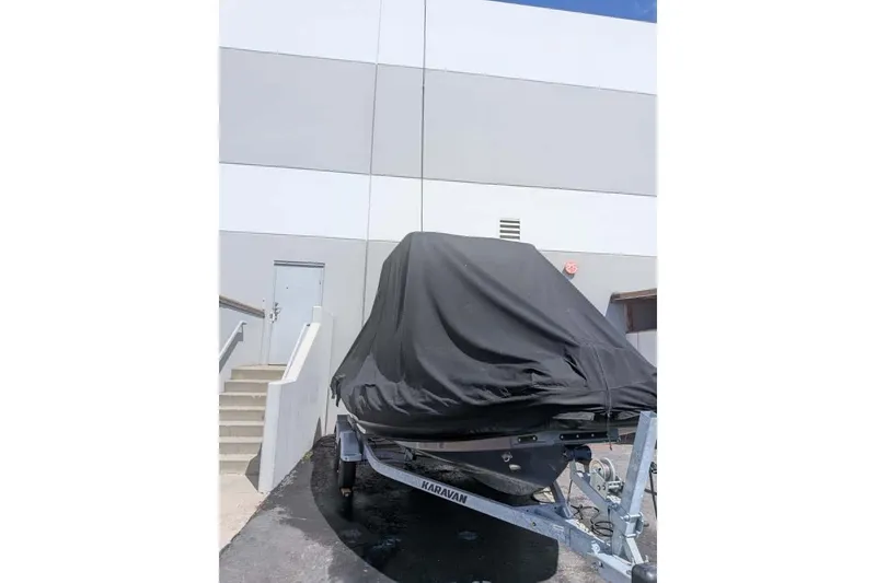 Slide: The Image of Covered Zodiac 20 boat on trailer, parked near a building, 2022 model. - 24