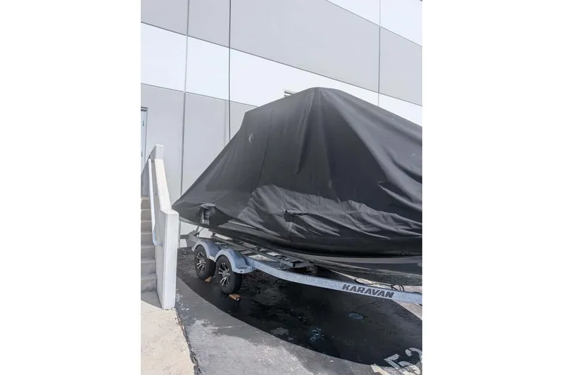Slide: The Image of Covered Zodiac 20 boat on trailer, parked beside a building, 2022 model. - 25