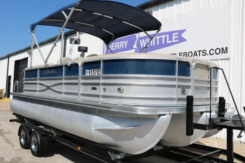 Slide: The Image of 2017 Berkshire 22 RFX Cts Tri-toon pontoon boat on trailer, with canopy, parked outside. - 4
