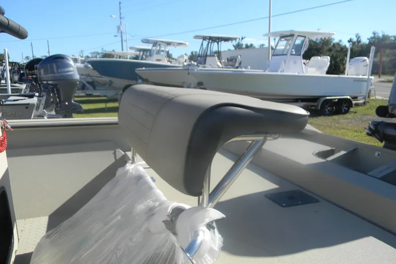 Slide: The Image of 2025 SeaArk Shadow 18 t boat interior with cushioned seating and visible outboard motor. - 10